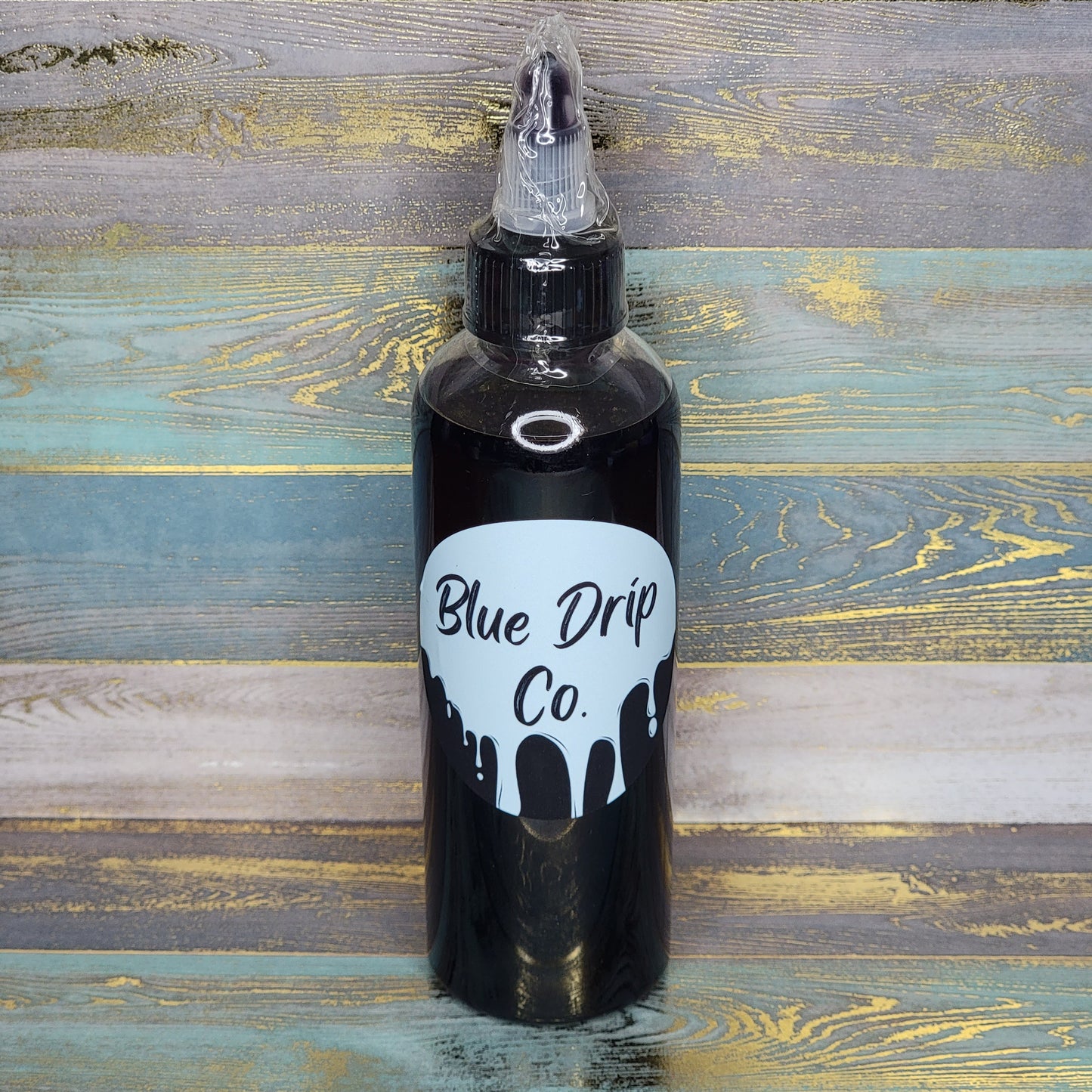 A bottle of liquid with a label reading 'Blue Drip Co.' and a drip design