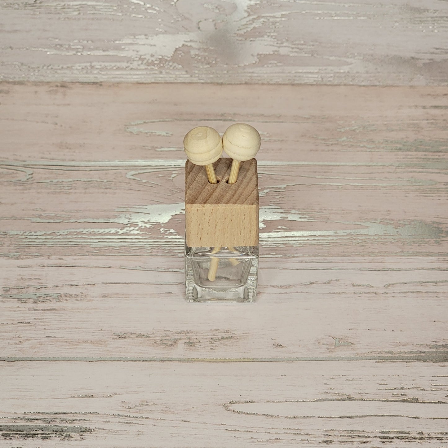 Two wooden knobs on a small wooden block placed on a textured surface.