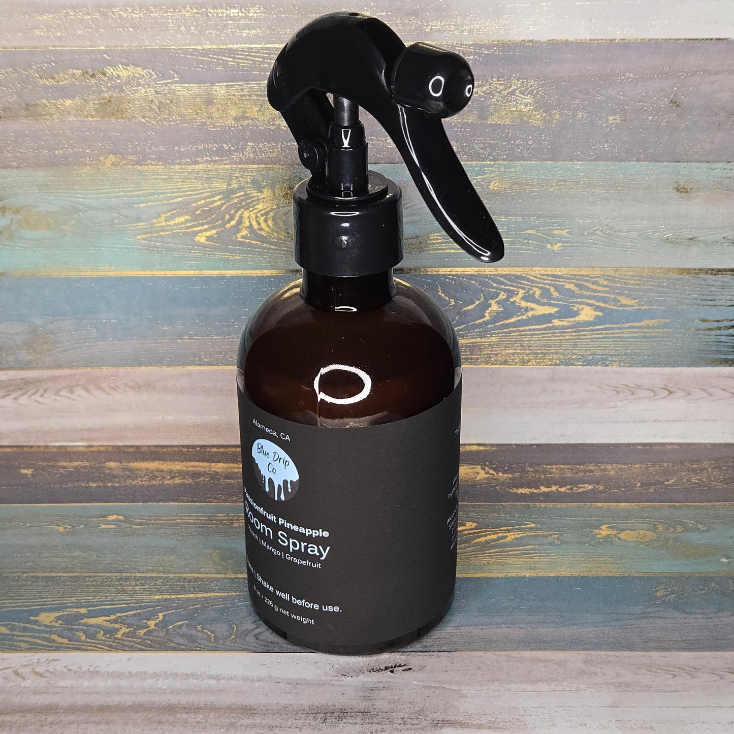 Brown spray bottle with black nozzle on a rustic wooden background.