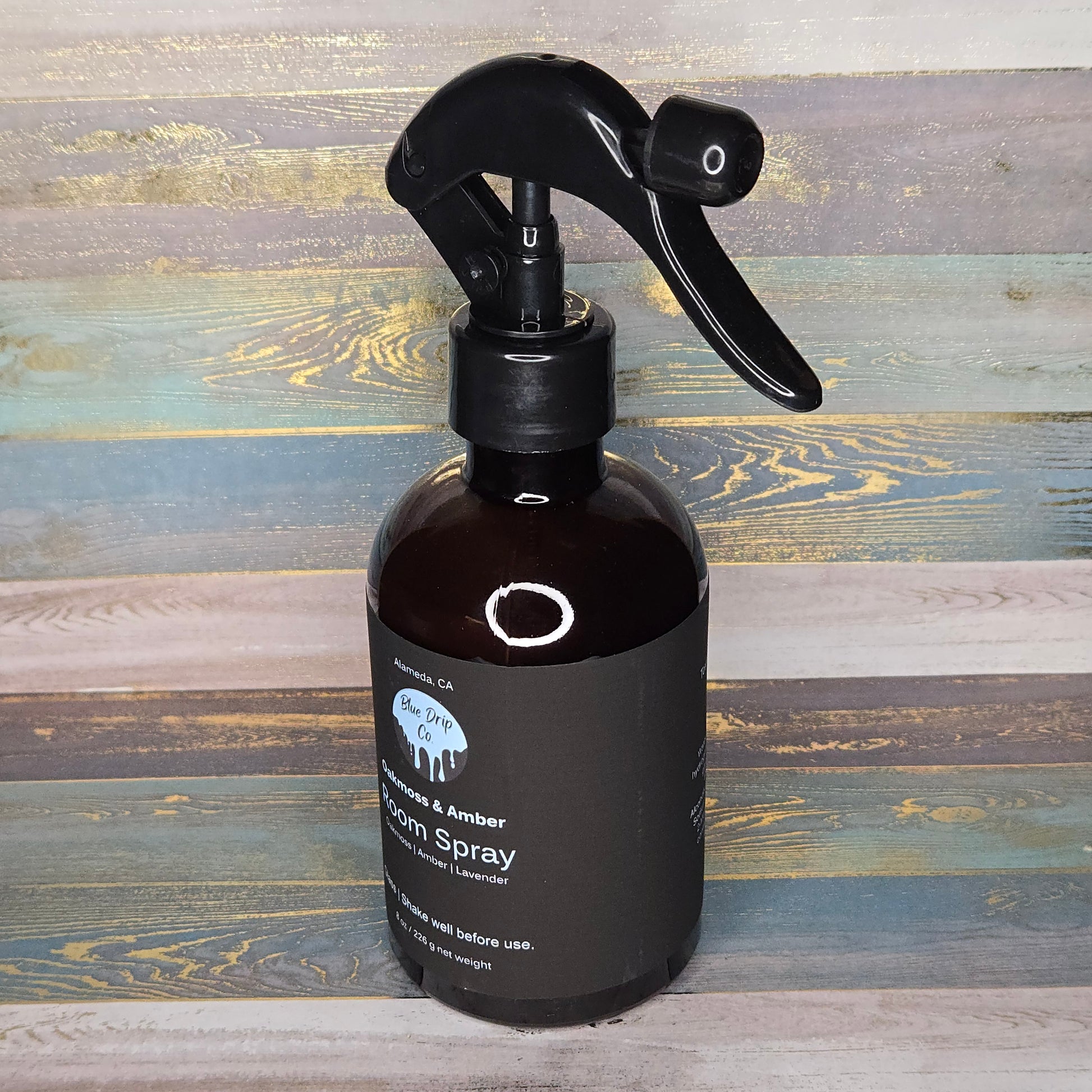 Bottle of room spray with a spray nozzle on a wooden background.