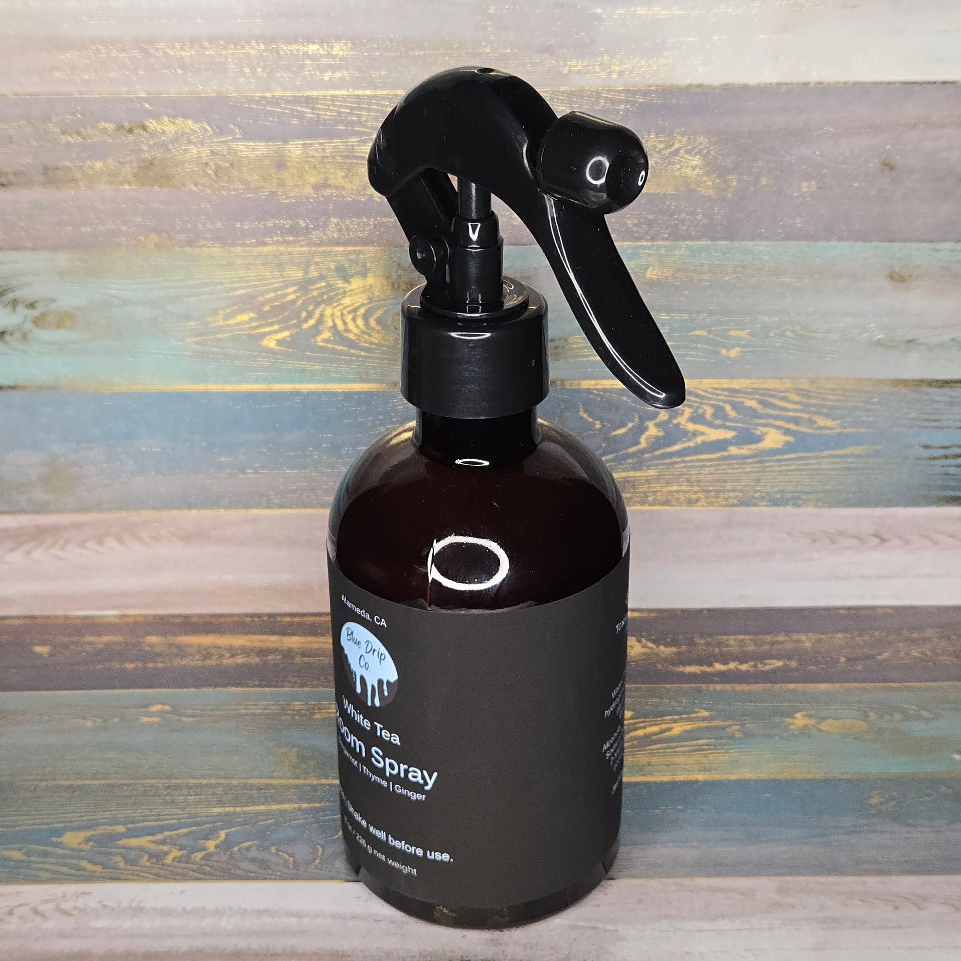 Brown spray bottle with a black nozzle on a wooden background.